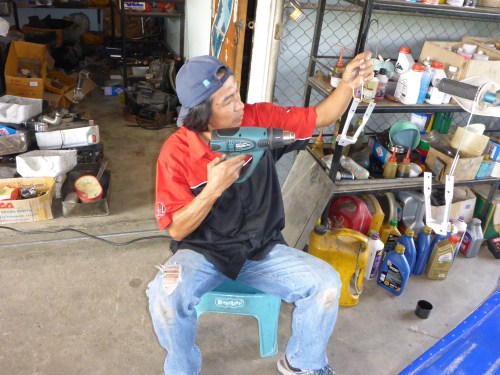 Nung, mechanic extraordinaire, powder-coating Anne's new highway pegs