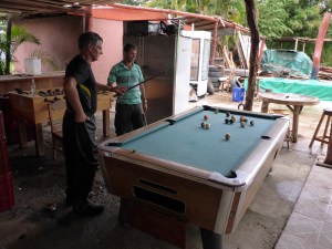 Anthony has a game of pool with one of the restaurant staff